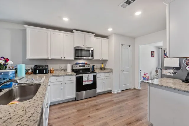 a kitchen with sink a microwave a refrigerator and cabinets