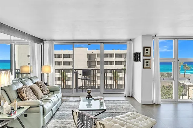 a living room with stainless steel appliances kitchen island granite countertop a sink a stove and a microwave
