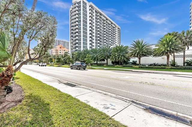 a view of a tennis court with building in the background