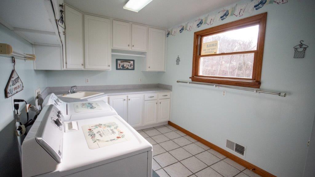 900 Lardintown Road Tarentum, PA 15084 - Photo 46 of 50 a kitchen with white cabinets a stove a sink and a window