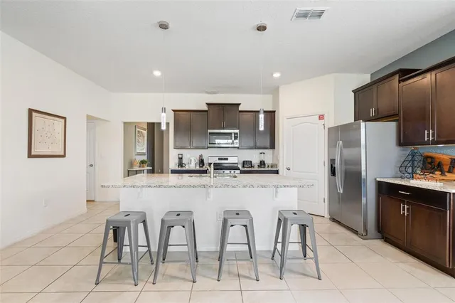 a kitchen with stainless steel appliances granite countertop a refrigerator and a stove top oven