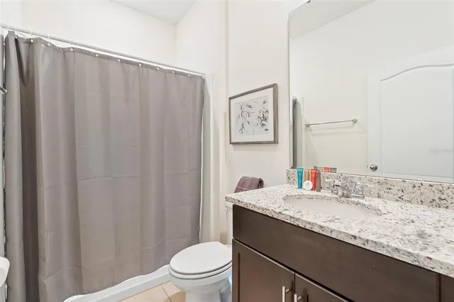 a bathroom with a granite countertop sink toilet and a mirror