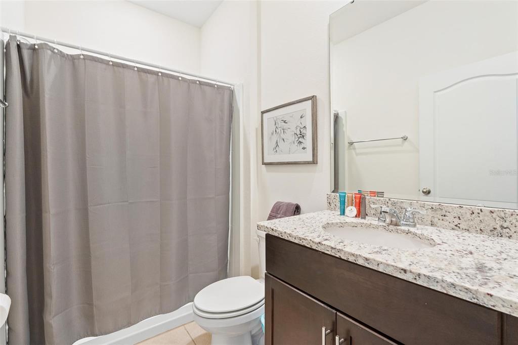 7841 Oak Reflection Loop Davenport, FL 33837 - Photo 19 of 44 a bathroom with a granite countertop sink toilet and a mirror