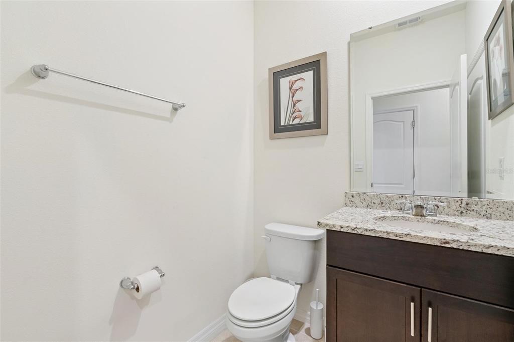 7841 Oak Reflection Loop Davenport, FL 33837 - Photo 21 of 44 a bathroom with a granite countertop sink mirror vanity and toilet