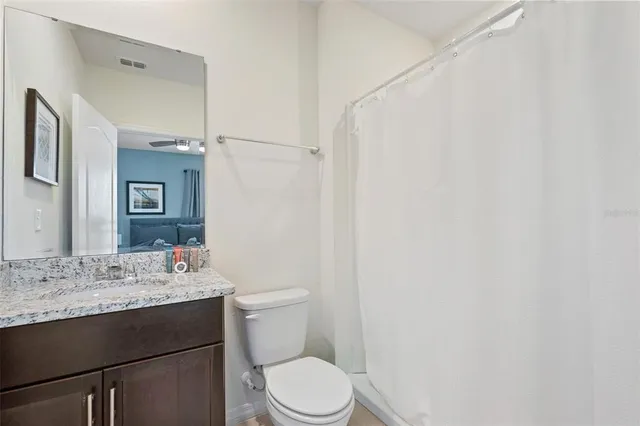 a bathroom with a sink vanity mirror and toilet