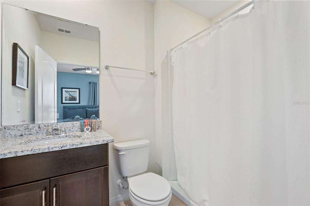 7841 Oak Reflection Loop Davenport, FL 33837 - Photo 26 of 44 a bathroom with a sink vanity mirror and toilet