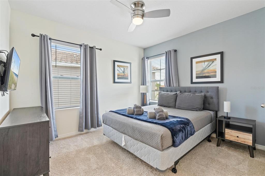 7841 Oak Reflection Loop Davenport, FL 33837 - Photo 27 of 44 a bedroom with a bed and a flat screen tv