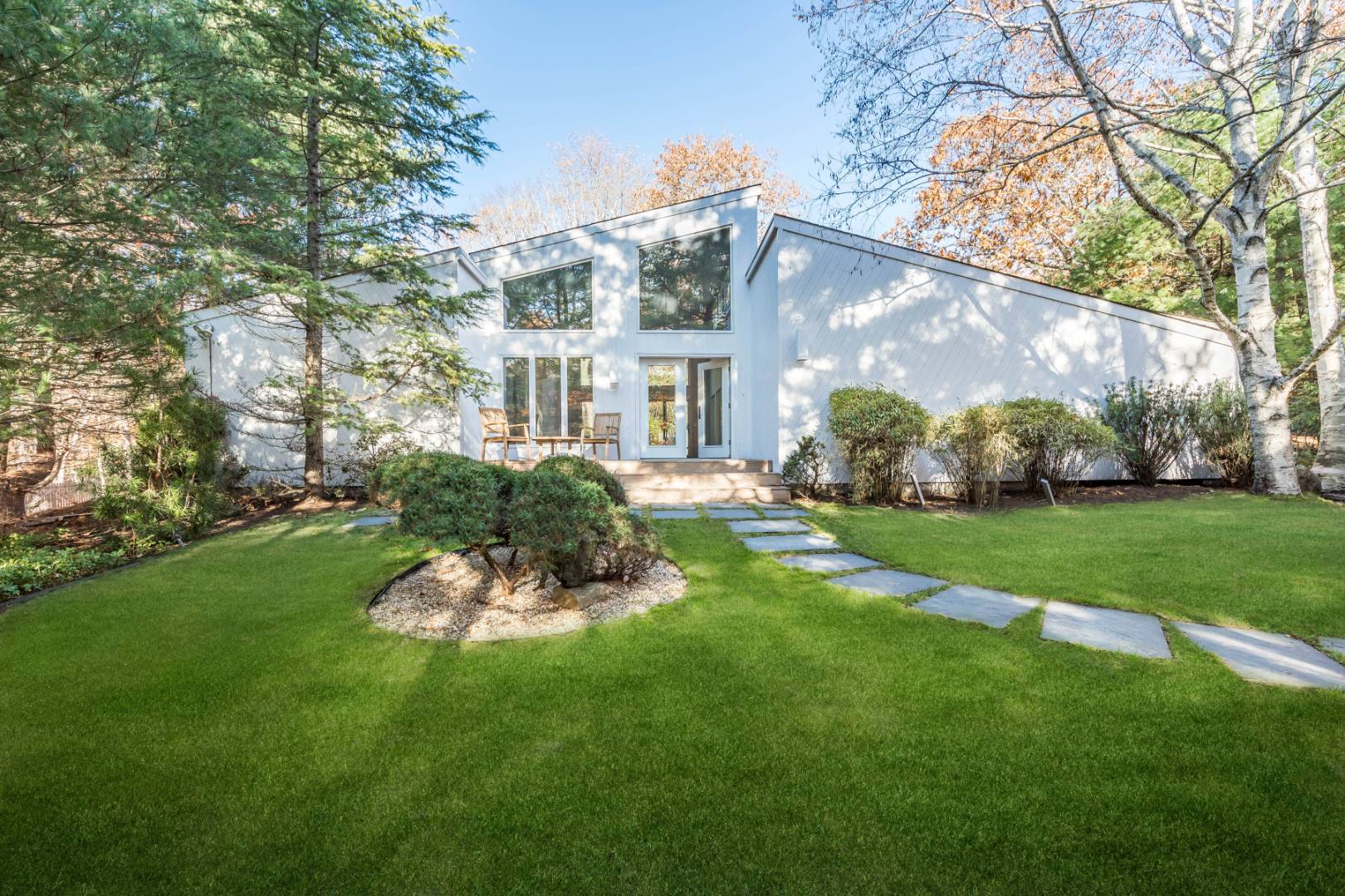 a front view of a house with a garden and plants