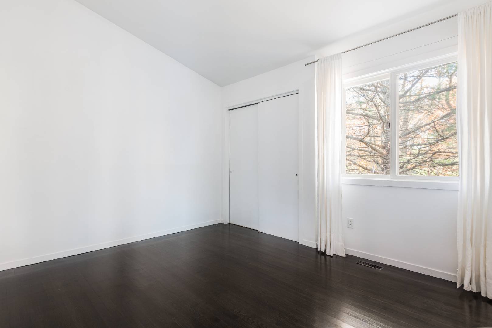 132 Springy Banks Road East Hampton, NY 11937 - Photo 23 of 37 an empty room with wooden floor and windows