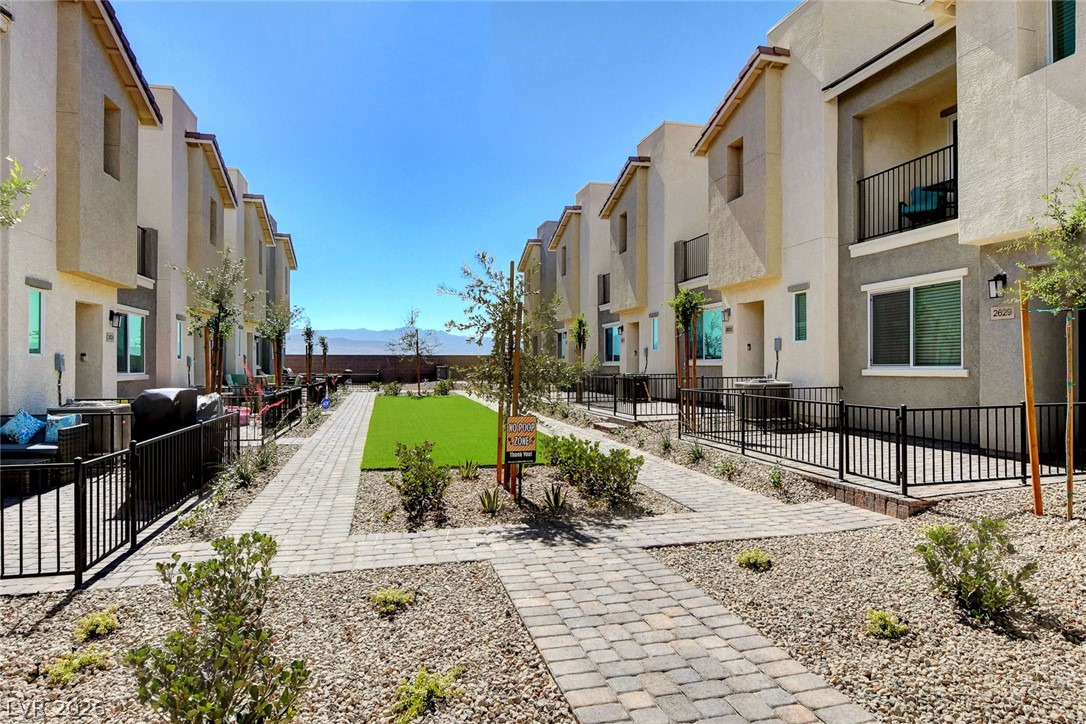 6924 Spicy Merlot Street North Las Vegas, NV 89086 - Photo 57 of 83 A community of modern residences featuring private patios and manicured common areas under a clear sky.