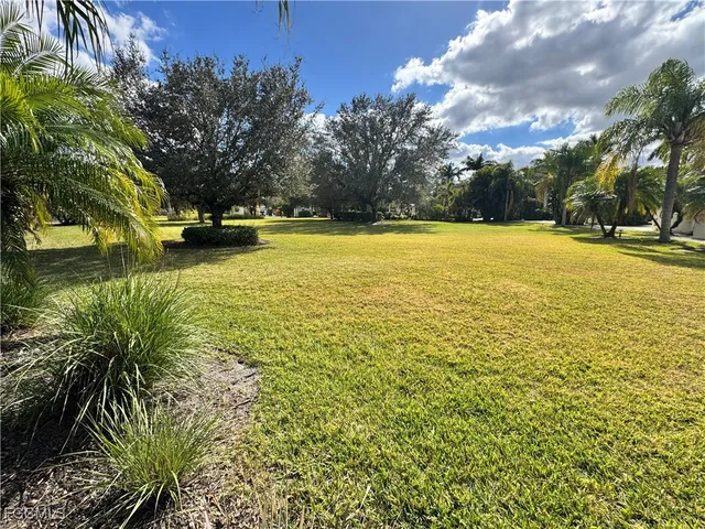a view of yard with swimming pool and green space