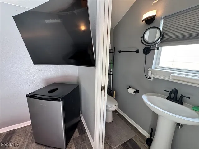 a bathroom with a toilet a sink and mirror