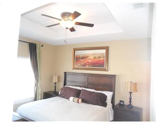 a bedroom with a large bed and a chandelier