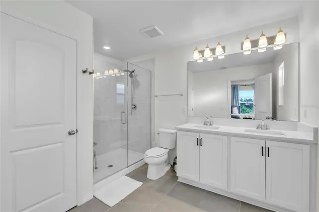 a bathroom with a double vanity sink mirror and toilet