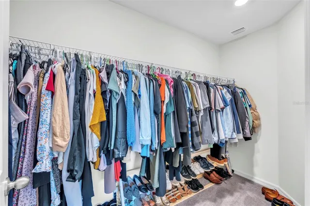 a view of walk in closet with clothes