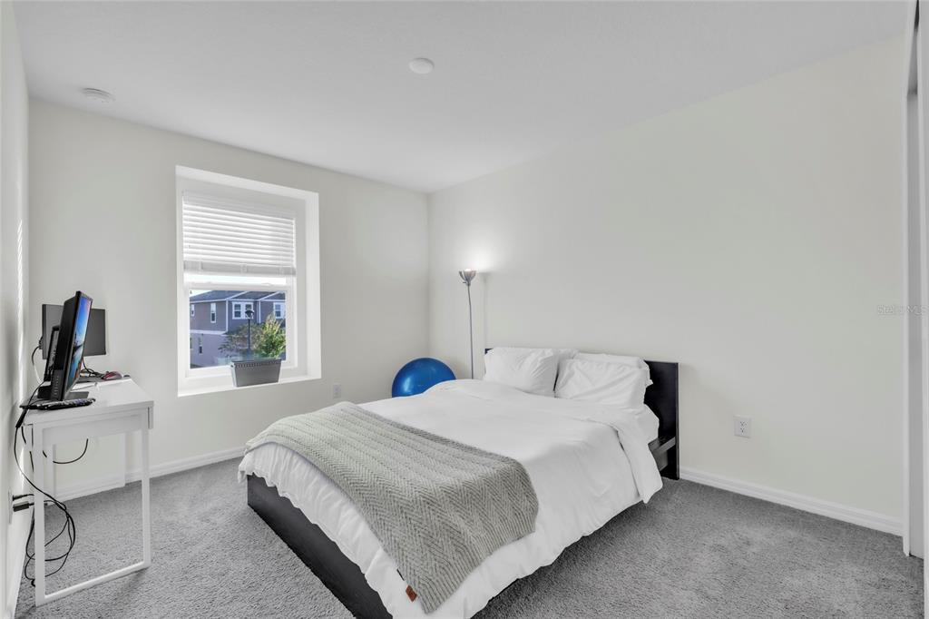 11512 Gallatin Trail Parrish, FL 34219 - Photo 21 of 39 a bedroom with a bed a flat screen tv and windows