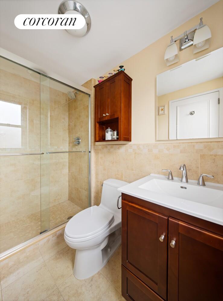 136 East 76th Street, Unit 15B Manhattan, NY 10021 - Photo 7 of 12 a bathroom with a sink a toilet and shower