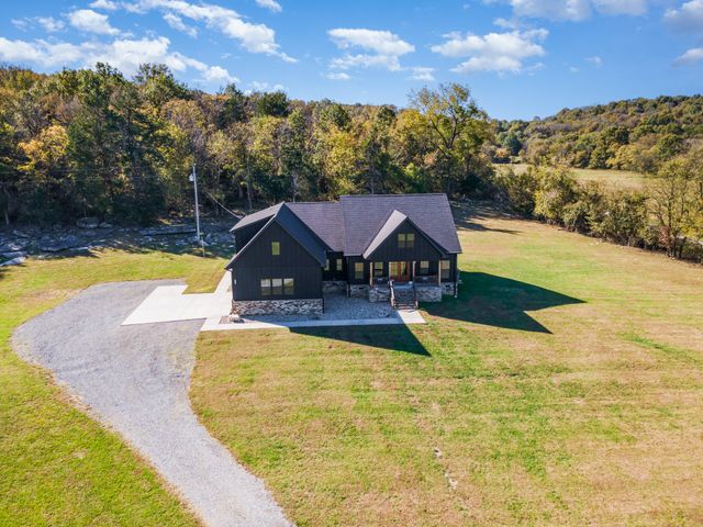 a view of a yard with plants and trees