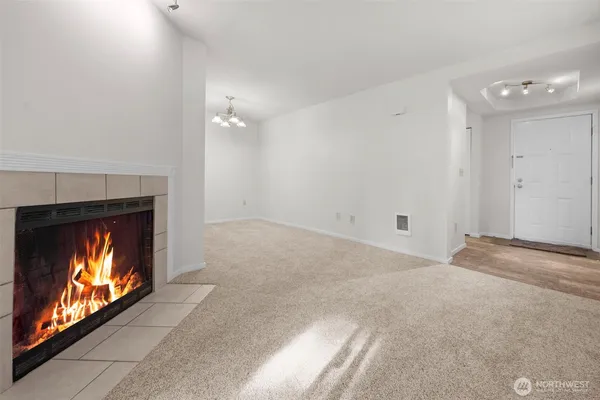 a view of an empty room with window and fire place