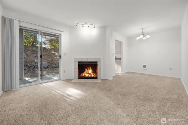 a view of an empty room with window and fire place
