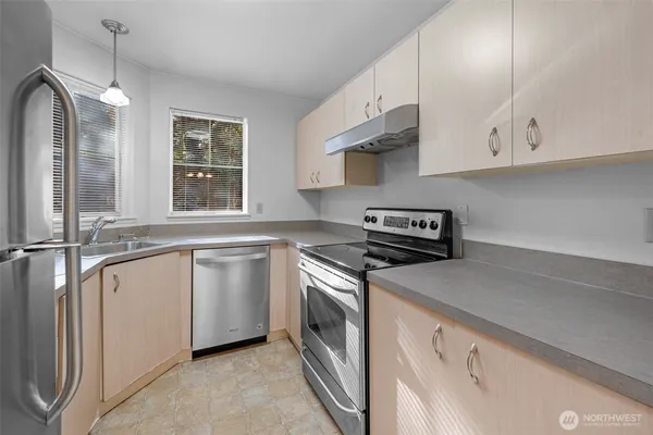 a kitchen with white cabinets and refrigerator