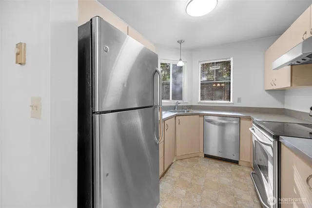 a kitchen with granite countertop stainless steel appliances a sink stove and cabinets