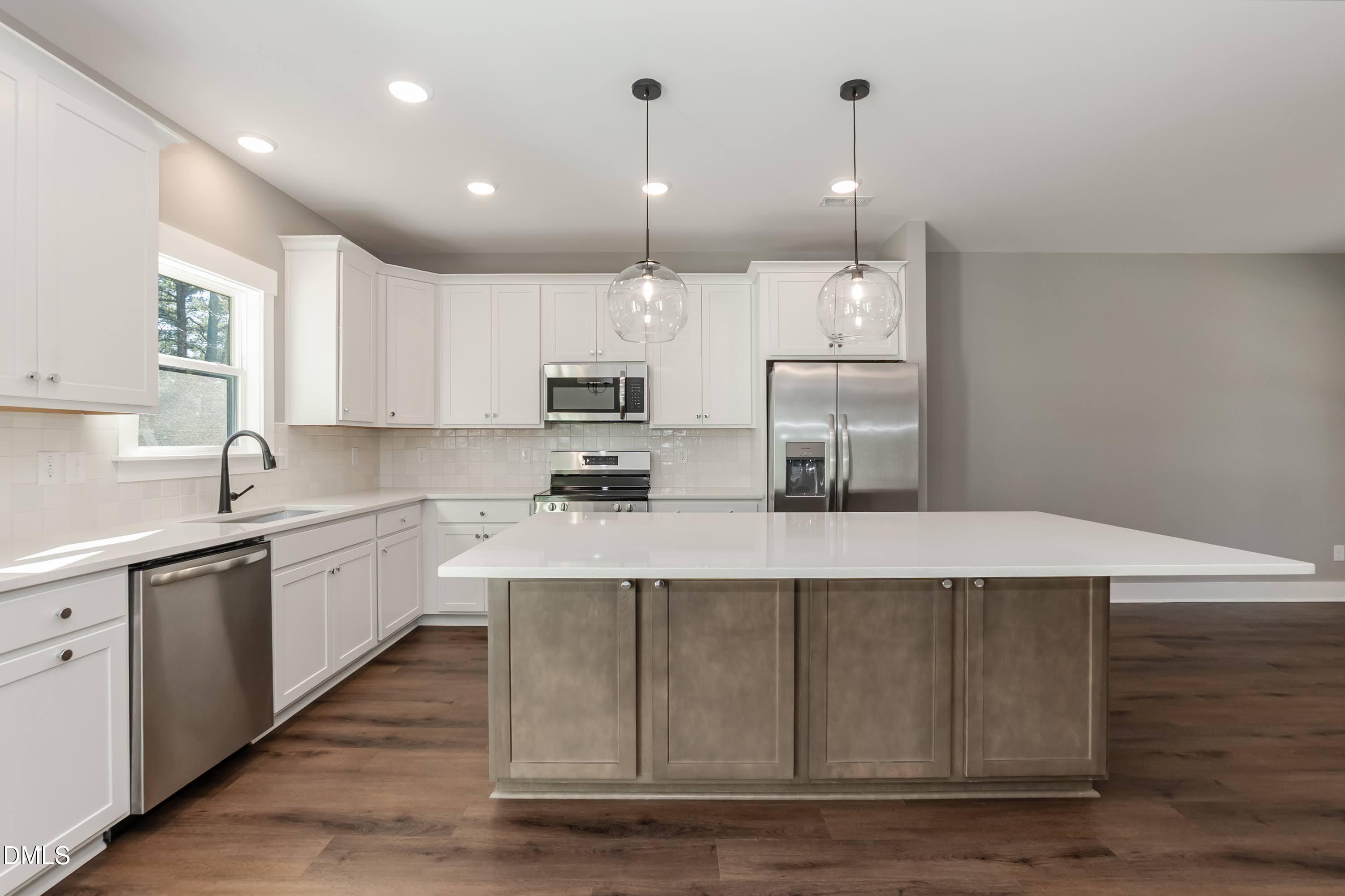 104 Buffalo Drive Spring Hope, NC 27882 - Photo 14 of 48 a kitchen with kitchen island white cabinets and stainless steel appliances