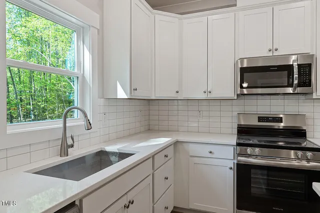 a kitchen with appliances a sink a stove and cabinets