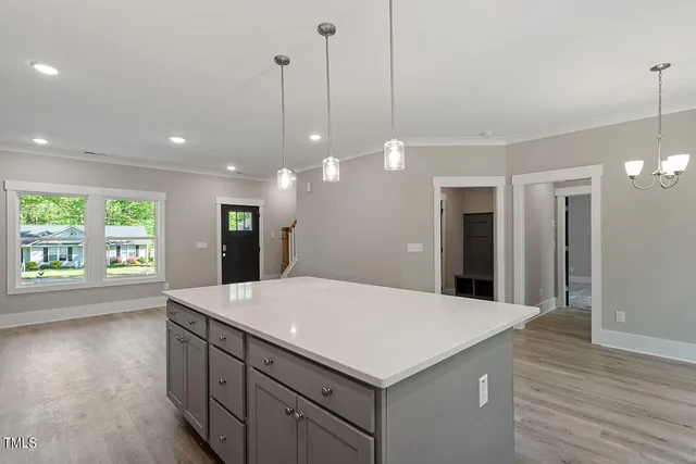 a kitchen with kitchen island a sink appliances and wooden floor