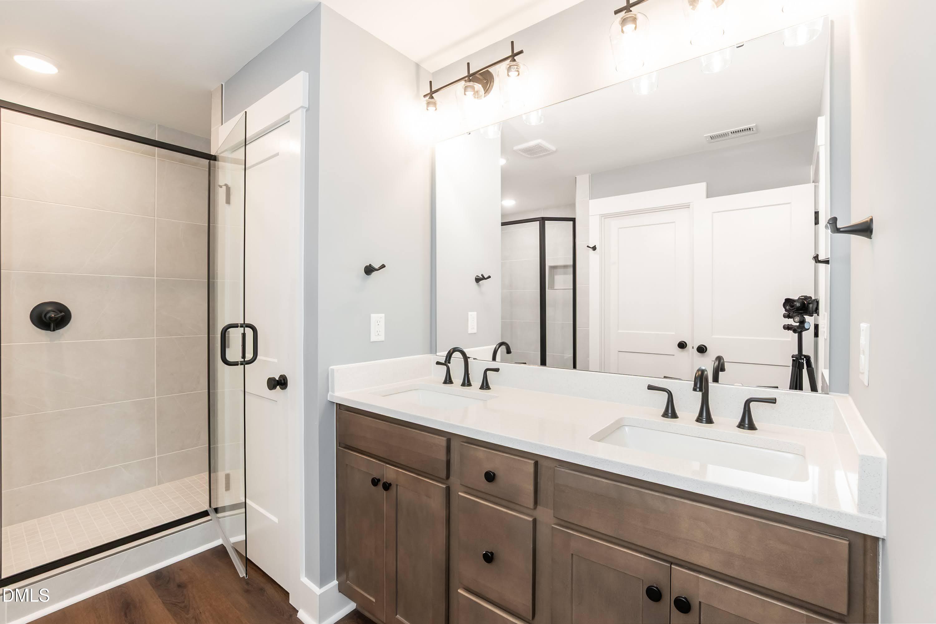 104 Buffalo Drive Spring Hope, NC 27882 - Photo 24 of 48 a bathroom with a double vanity sink a mirror a glass door a shower and vanity