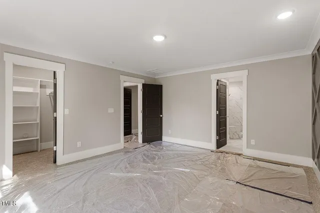 an empty room with closet and windows