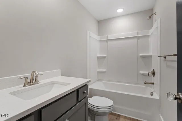 a bathroom with a sink toilet vanity and shower