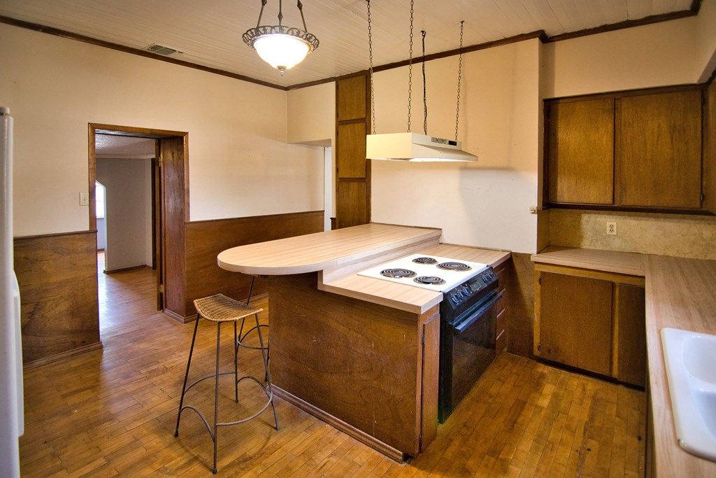 117 Robin Avenue Mason, TX 76856 - Photo 14 of 22 a kitchen with a stove cabinets and wooden floor