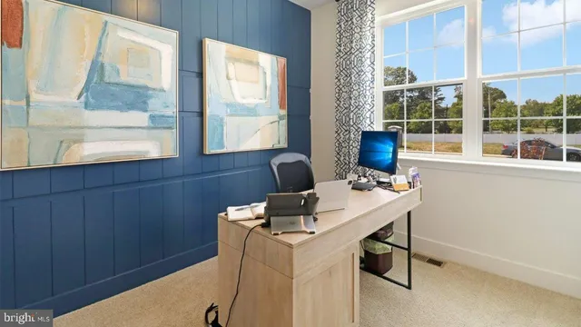 a view of a workspace with furniture and a window
