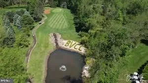 an aerial view of a house with a yard and trees all around