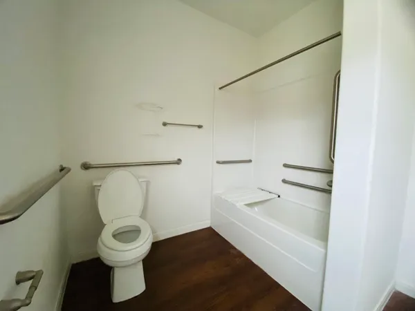 a white toilet sitting next to a bathroom sink and vanity