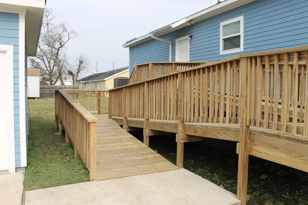 a view of a balcony with wooden floor and fence
