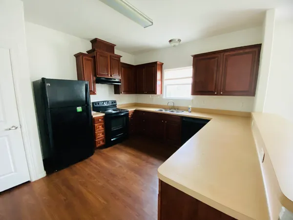 a kitchen with stainless steel appliances granite countertop a refrigerator a sink a stove and island