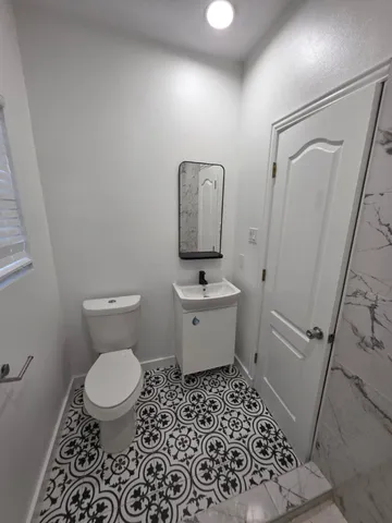 a bathroom with a toilet a sink and a mirror