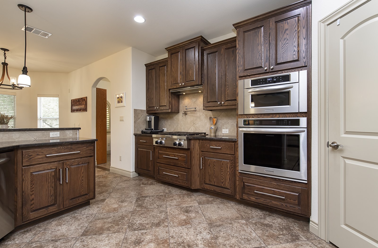 213 Acker Road Georgetown, TX 78633 - Photo 10 of 32 a kitchen with granite countertop wooden cabinets and stainless steel appliances
