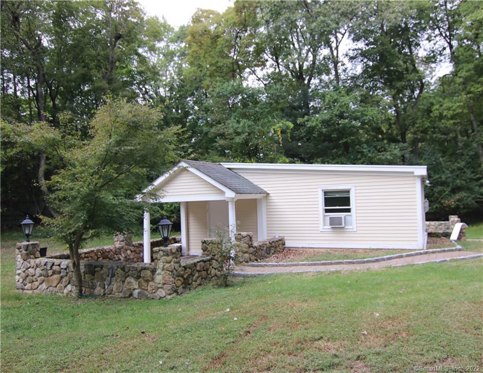 578 Scofieldtown Road, Unit COTTAGE Stamford, CT 06903 - Photo 1 of 1 a backyard of a house with table and chairs