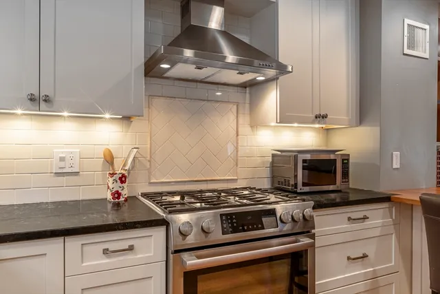 a stove top oven sitting inside of a kitchen