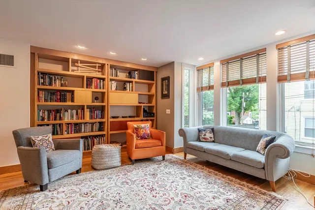 a living room with furniture and a book shelf