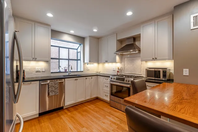 a kitchen with stainless steel appliances granite countertop a stove a sink and a refrigerator