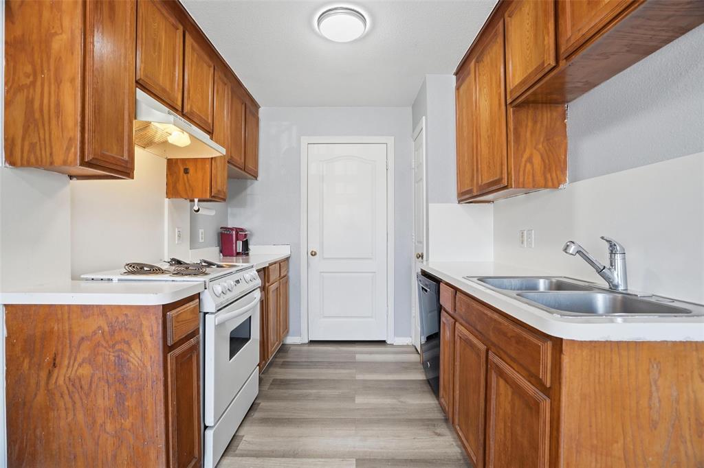 609 Race Street Crowley, TX 76036 - Photo 6 of 18 a kitchen with granite countertop a sink stove and cabinets