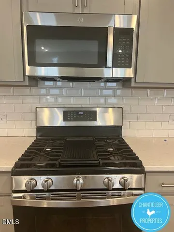 a stove top oven sitting inside of a kitchen