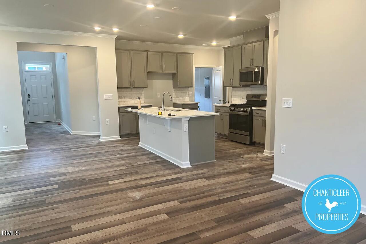5549 Mill Dam Road Wake Forest, NC 27587 - Photo 3 of 16 a kitchen with stainless steel appliances granite countertop a stove a sink and a refrigerator