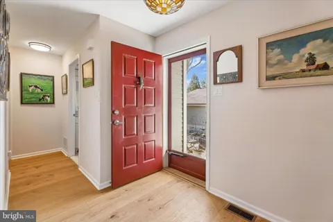 a view of a hallway with wooden floor and entryway
