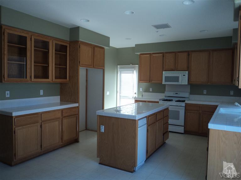 1113 Unidad Way Oxnard, CA 93030 - Photo 4 of 5 a kitchen with stainless steel appliances granite countertop a stove a refrigerator and a sink