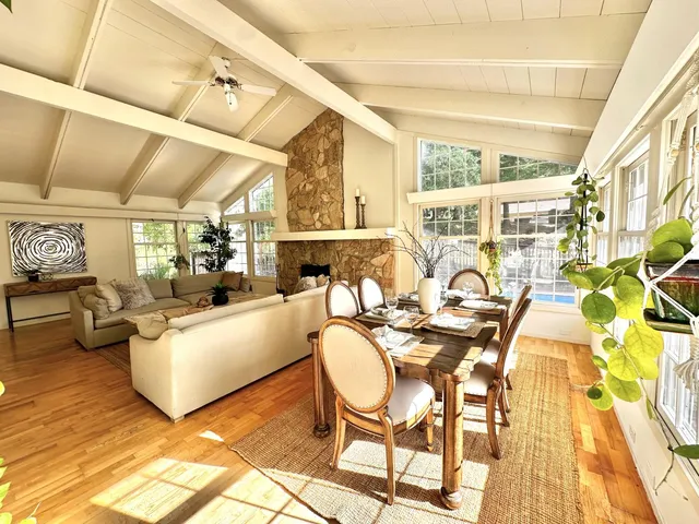 a living room with fireplace furniture and a large window